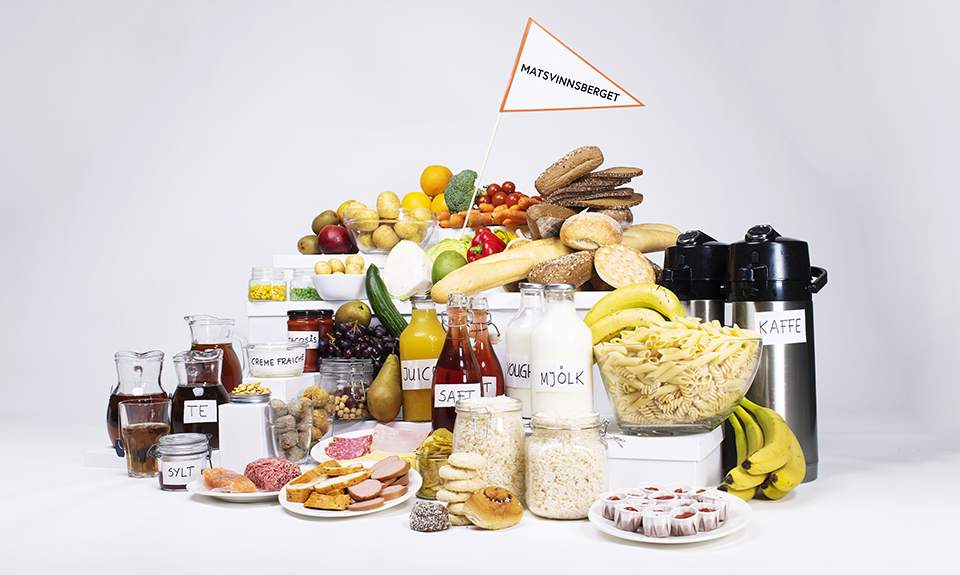 Foto på en massa olika livsmedel med en vimpel där det står "matsvinnsberget".